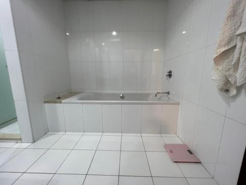 biała łazienka z wanną i podłogą wyłożoną kafelkami w obiekcie BLVBD Central Full Burj View 1402 w Dubaju