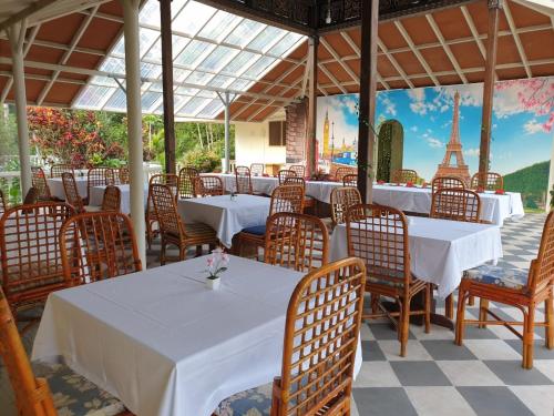 um restaurante com mesas e cadeiras e vista para a torre Eiffel em Hotel Toraja Prince em Tobonga