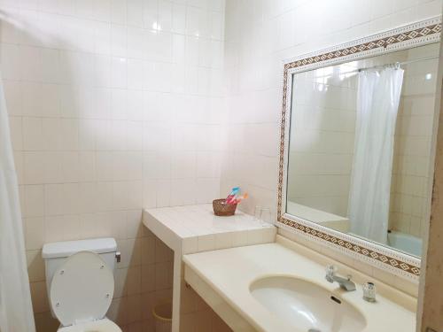 uma casa de banho com um lavatório, um WC e um espelho. em Hotel Toraja Prince em Tobonga