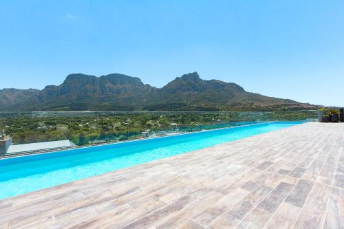 una vista de la piscina infinita con montañas en el fondo en Newlands Peak Aparthotel by Totalstay en Ciudad del Cabo