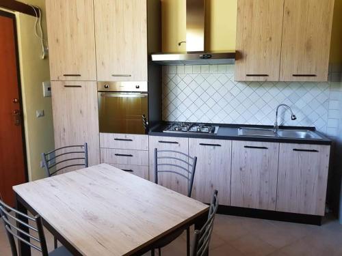 Una cocina con una mesa, un fregadero y una estufa. en Il nido di Torre Lorenzetta, en Massa Martana