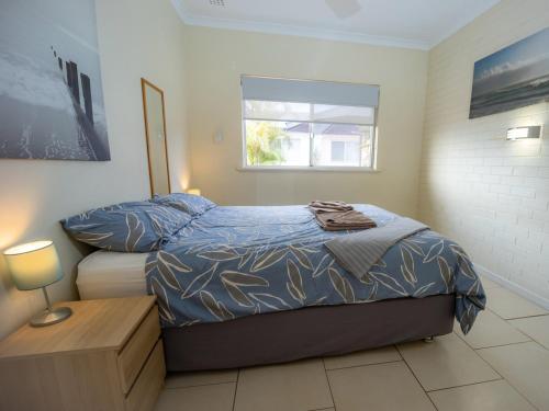 a bedroom with a bed and a window at API Pelican Beach Front Apartments Kalbarri in Kalbarri