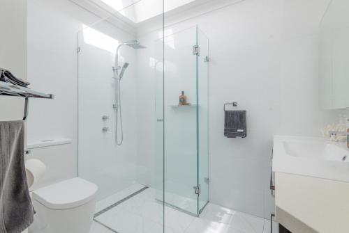 La salle de bains est pourvue d'une cabine de douche en verre et de toilettes. dans l'établissement Mindarie Retreat, à Mindarie