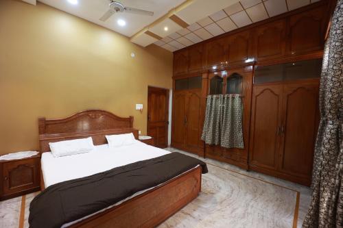 a bedroom with a bed and wooden cabinets at Kapoor Sahab Homestay : it's a home away from home. in Varanasi