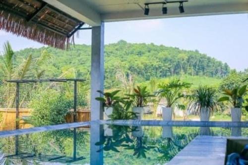 balcón con vistas a una colina con palmeras en Ostrich homestay - Venue Travel, en Ba Vì