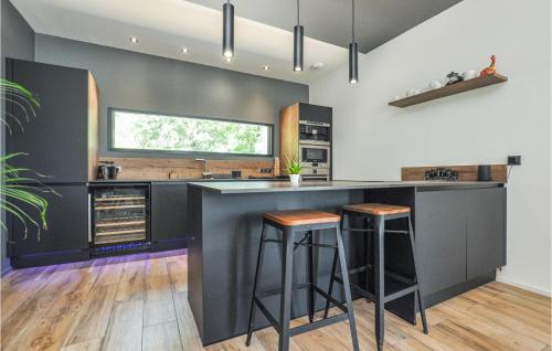 une cuisine avec un comptoir noir et des tabourets dans l'établissement Villa Noelie, à Callian