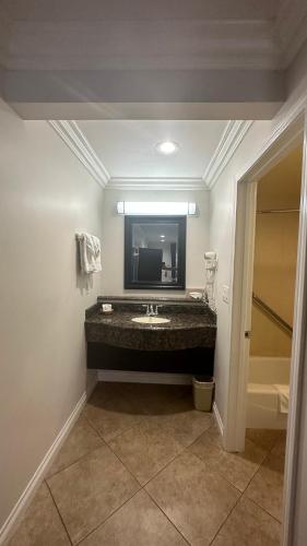 a bathroom with a sink and a mirror at Garden Inn and Suites Glendora in Glendora