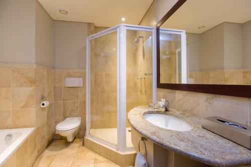 y baño con lavabo, ducha y aseo. en Garden Route Hotel en Mossel Bay