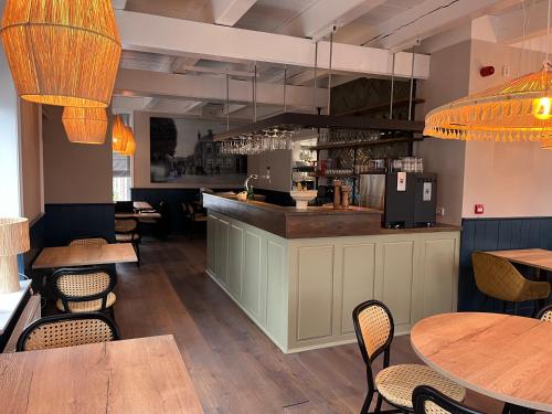 a restaurant with tables and chairs and a bar at Hotel Restaurant Toxopeus in Anjum