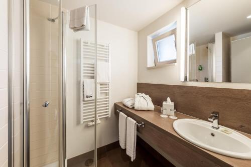 a bathroom with a sink and a shower at BEECH Resort Plauer See in Plau am See