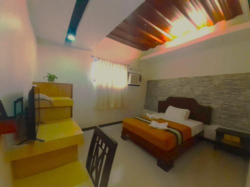 a bedroom with a bed and a television in it at MelSol Hotel in Bantay