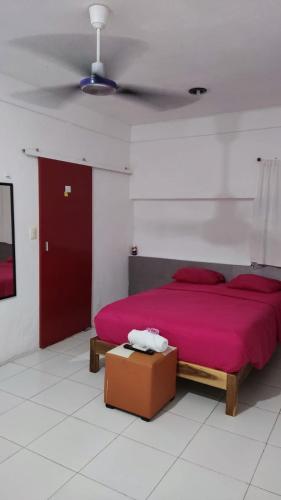 a bedroom with a red bed and a red door at Ángel in Campeche