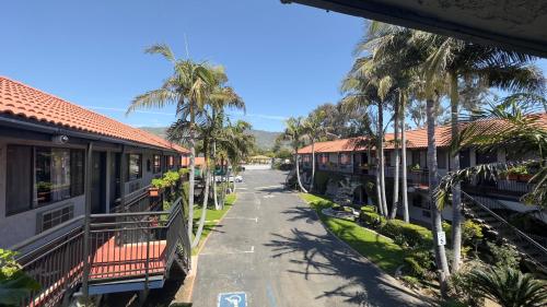 a street with palm trees next to a building at Garden Inn and Suites Glendora in Glendora