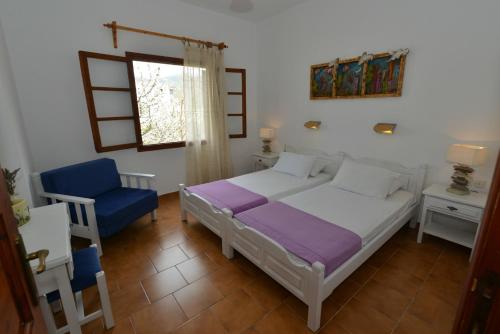 una camera da letto con un letto e una sedia blu di Anofli Suites a Skopelos Town