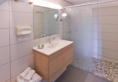 a bathroom with a sink and a shower at Logis Hôtel Restaurant & Spa les Remparts in Salers