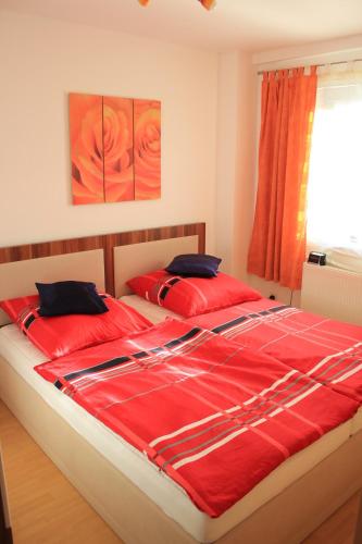 um quarto com um grande edredão vermelho numa cama em Ferienwohnung Athena em Pirna