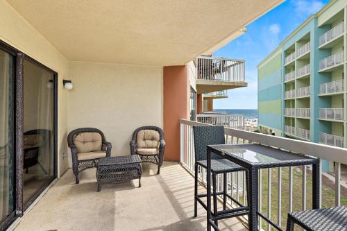 einen Balkon mit Stühlen und einem Tisch mit Meerblick in der Unterkunft Harbor Place 206 in Gulf Shores