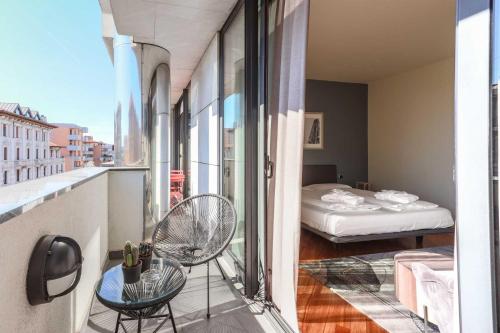 AR Prestige Penthouse - Soho في بيرغامو: غرفة مع شرفة مع سرير وغرفة مع نافذة