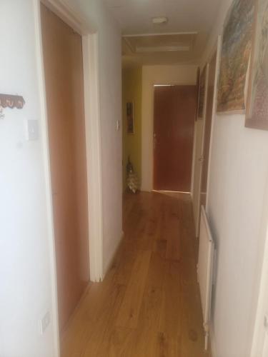 een lege hal met een harde houten vloer in een huis bij The Bungalow in Kent