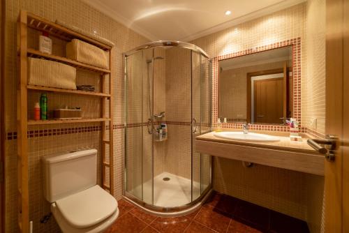 y baño con ducha, aseo y lavamanos. en Ático Vilanova en Villanueva de Arosa