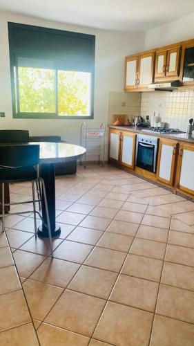 a kitchen with a table in the middle of it at Lovely 2 bedrooms appartment with rooftop in Temara