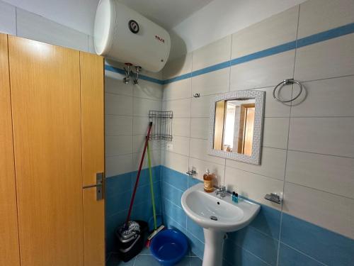 a bathroom with a sink and a mirror at Comfort 1 Apartment in Sarandë