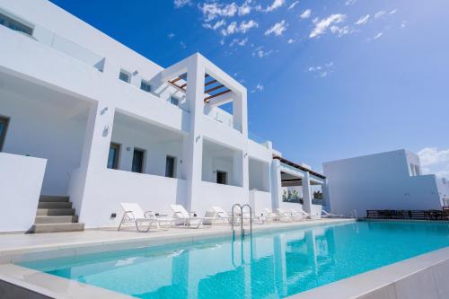 a villa with a swimming pool and white at Kouros Blanc Resort & Suites in Pounda