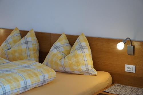 a bed with yellow and blue pillows on it at Waalhof Ferienwohnung Kastanie in Silandro