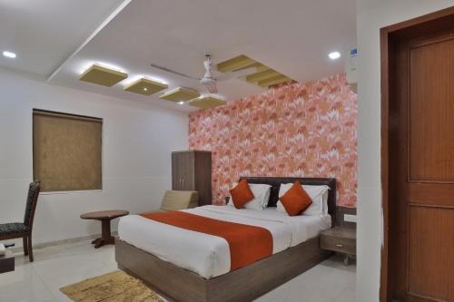 a bedroom with a bed and a desk and a chair at Hotel Sadbhav in Ahmedabad