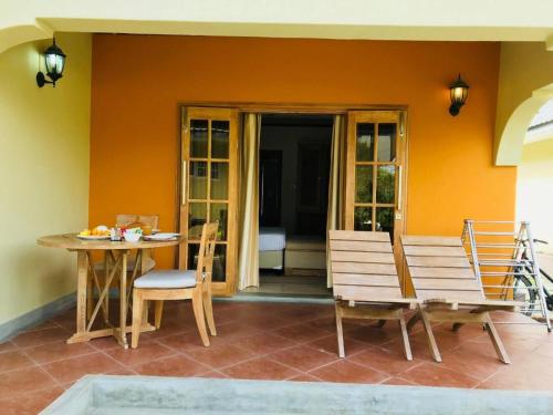 a porch with a table and a bench and a table at Villa Source D'Argent in La Digue
