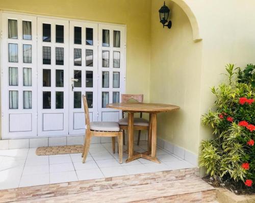 a patio with a table and chairs next to a door at Villa Source D'Argent in La Digue