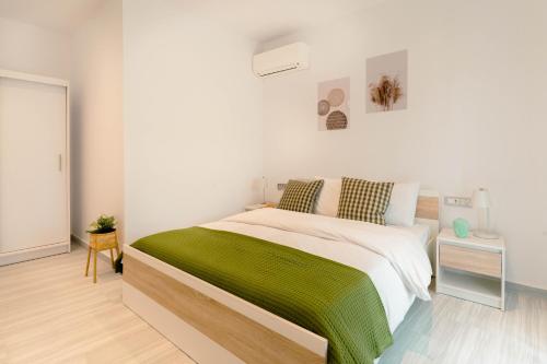 a bedroom with a large bed with a green blanket at Kaliva Residence in Kalamaki
