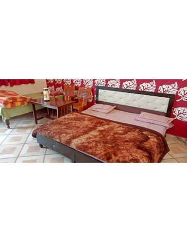 um quarto com uma cama grande e uma mesa em Hotel Omkar & Restaurant, Uttarkashi em Uttarkāshi