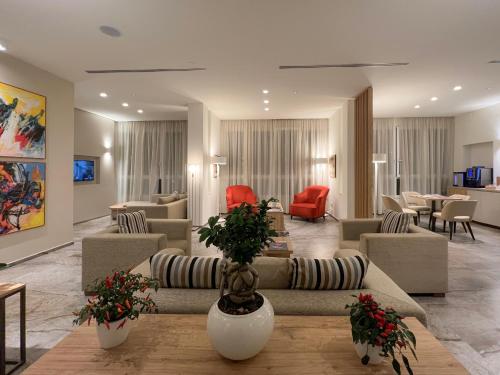 a living room with couches and tables and chairs at Hotel Rex in Livorno