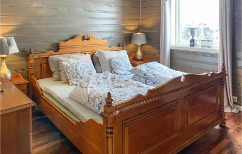 1 dormitorio con cama de madera con sábanas y almohadas blancas en Beautiful Home In Stryn With Kitchen, en Stryn