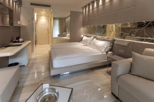 a bedroom with a bed and a living room with a couch at Park Hotel Imperial in Limone sul Garda
