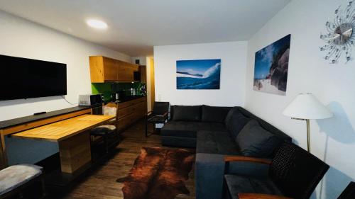ein Wohnzimmer mit einem Sofa und einem Flachbild-TV in der Unterkunft Michels Apartment in Titisee-Neustadt