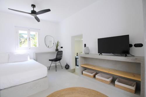 biały pokój z łóżkiem i telewizorem z płaskim ekranem w obiekcie 30villa Rd Studio w mieście Rodos