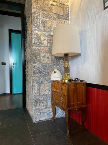 una lámpara en una mesa junto a una pared de ladrillo en Helga's Guesthouse, en Lin
