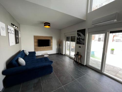 a living room with a blue couch and a tv at LuxVilla AURORA in Vodice