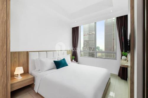 a bedroom with a white bed and a window at Sattva by Kozystay - Next to Mall in Jakarta