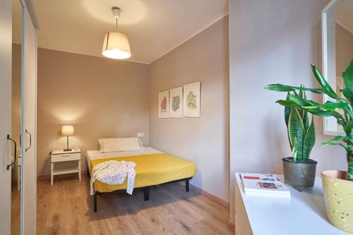 a bedroom with a bed and a potted plant at Ideal 3 bedroom apartment in Sant Andreu in Barcelona