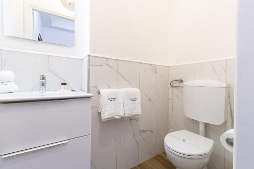 een witte badkamer met een toilet en een wastafel bij da ARMIDA VIP Flat in Napels