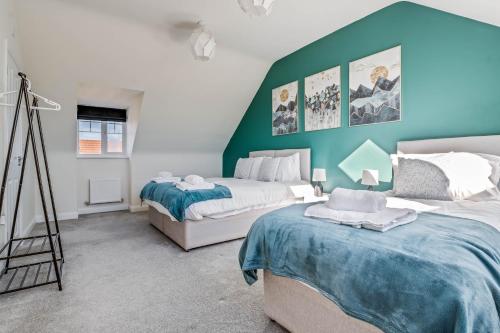 una camera con due letti e una parete verde di Beautiful and Comfortable Home away from Home a Northampton