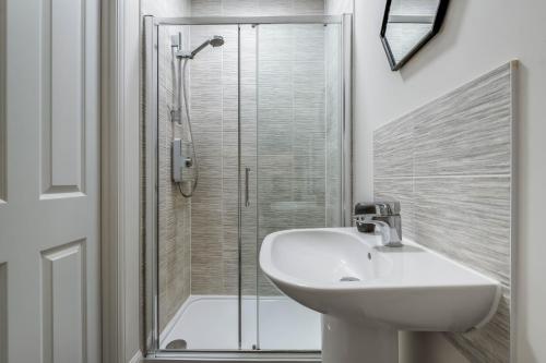 a bathroom with a sink and a shower at Beautiful and comfortable home away from home with free parking, fast wifi and white crisp hotel standard linen hosted by Our Home Short Stays in Northampton