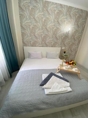 a bedroom with a bed with towels on it at Жк Арман двухкомнатная квартира в центре города/ Zhk Arman one-bedroom apartment in the city center in Atyraū