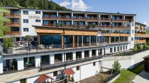 un hotel en las montañas con balcón en Hotel Watles en Malles Venosta