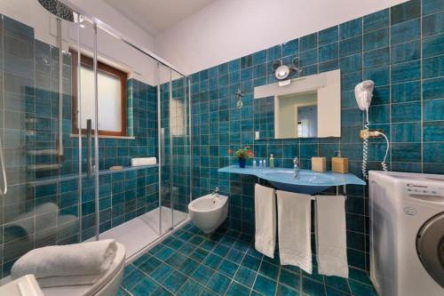 ein blau gefliestes Bad mit einem Waschbecken und einer Dusche in der Unterkunft Maison Marianna in Sorrent