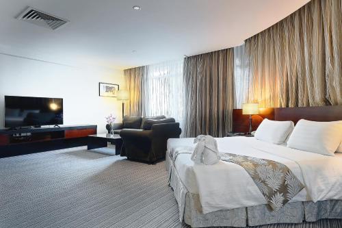 a hotel room with a bed and a television at Hotel Sixty3 in Kota Kinabalu