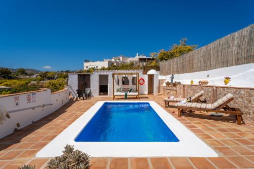 een villa met een zwembad en een patio bij Casa Herrero in Nerja